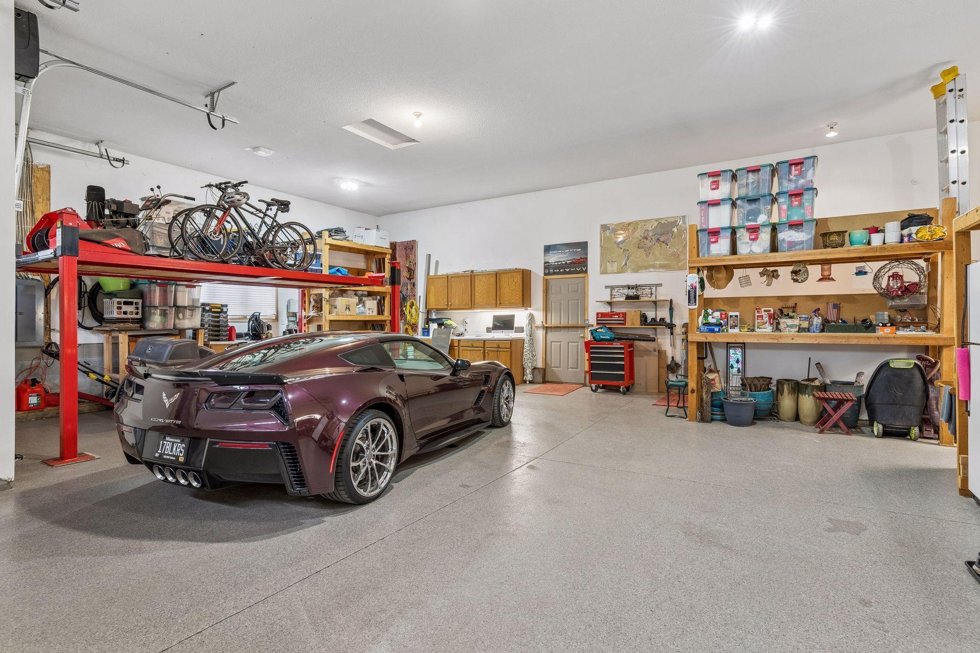 Angled insulated garage, oversized wide and deep, complete with a 13' ceiling height, epoxy floor with a floor drain, utility sink, central vacuum and two service entry doors for added convenience.