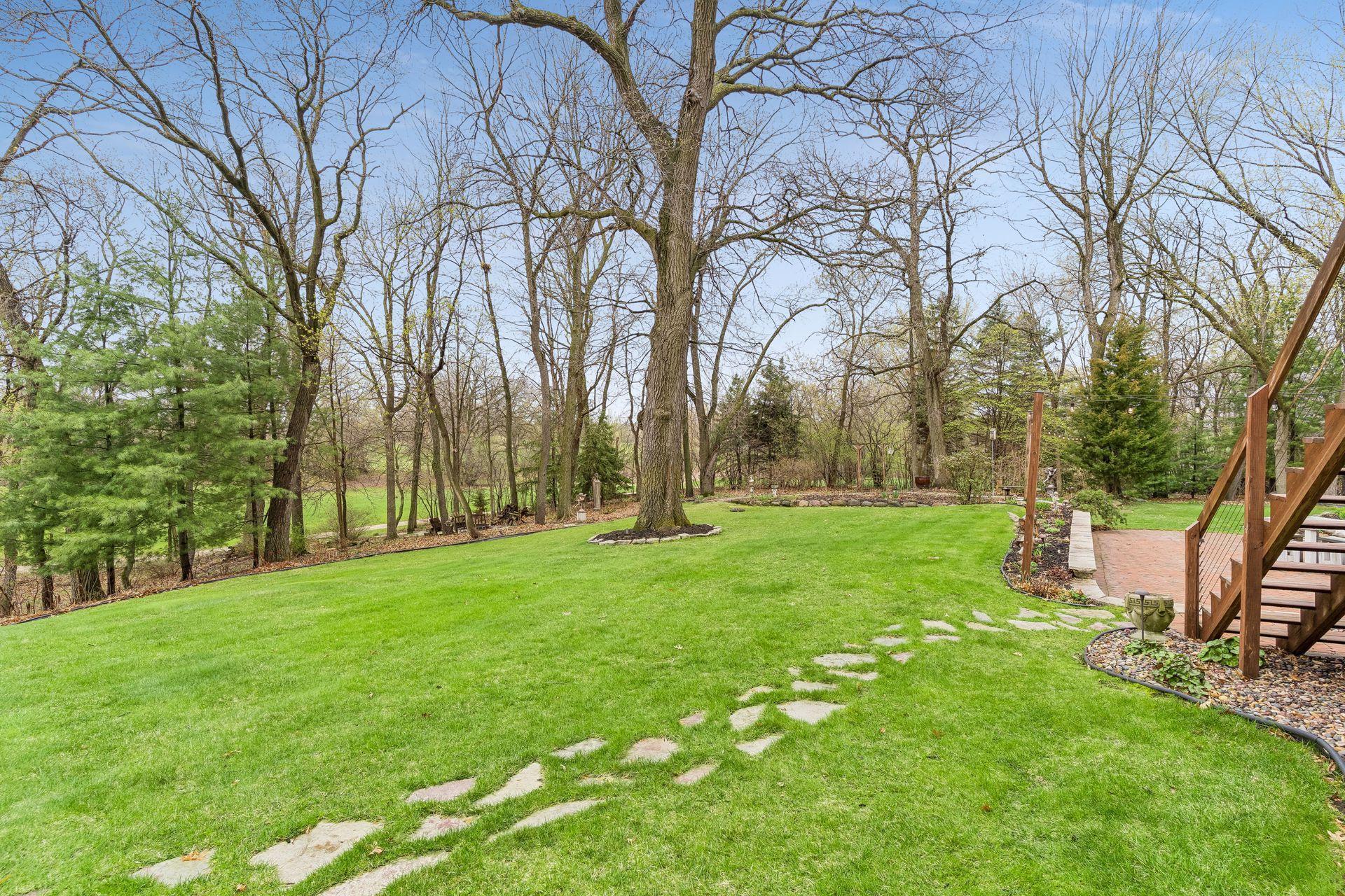 Spacious flat backyard, wrapped by mature trees, that welcome a private and tranquil setting.