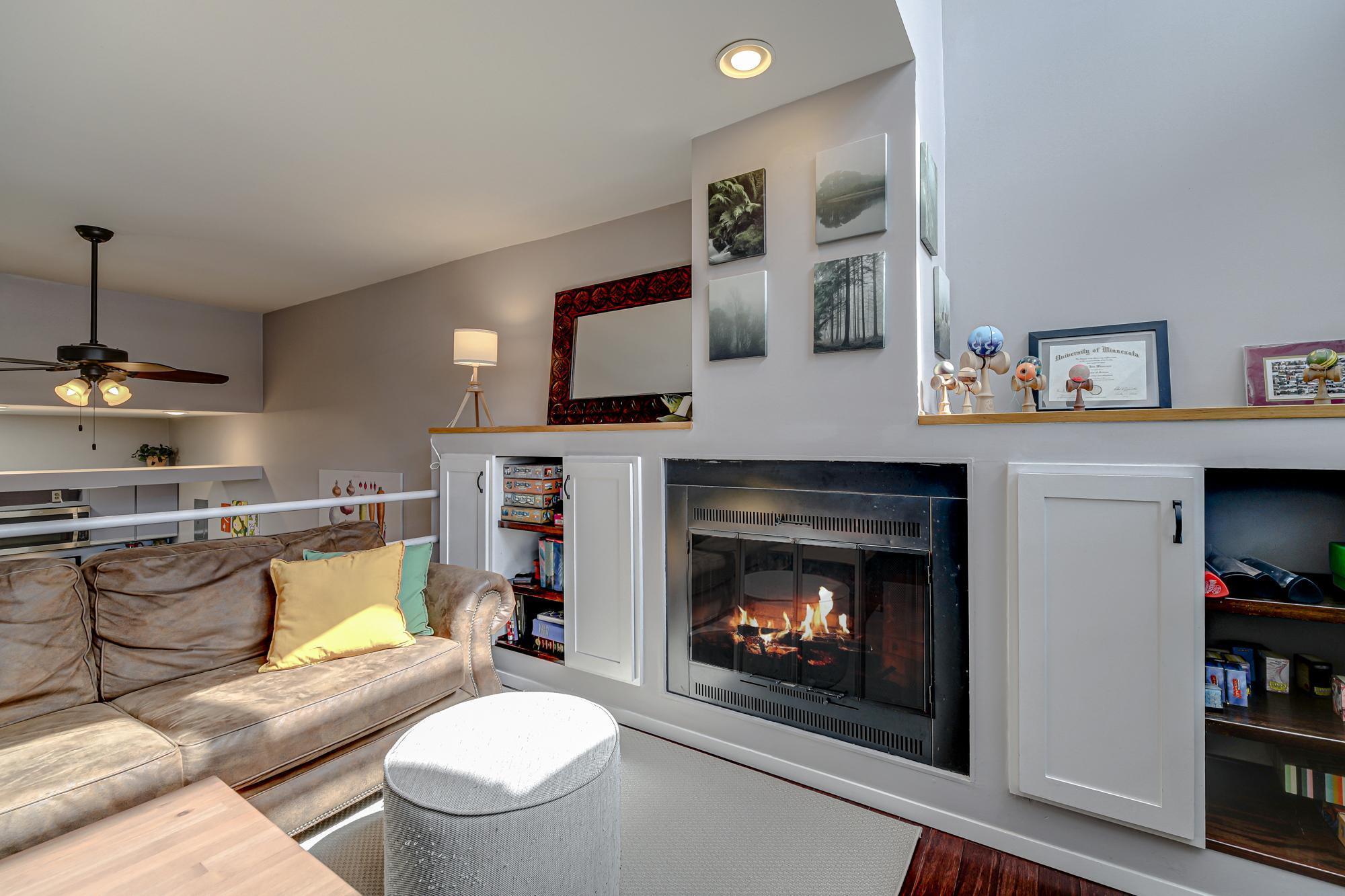 Charming wood burning fireplace with custom built shelving and cabinets surrounding