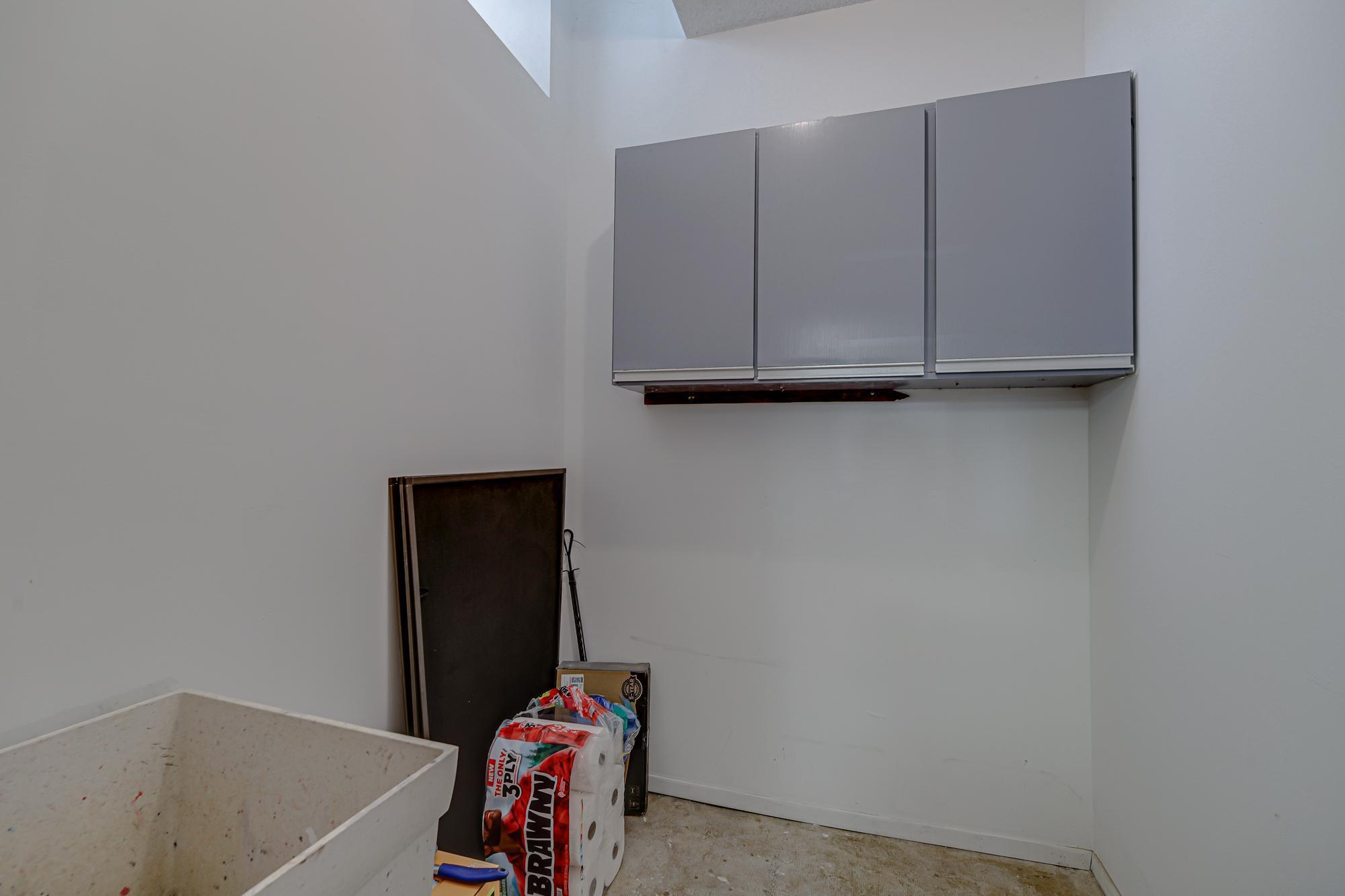 Bonus storage room with built in cabinets and a utility sink