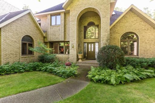 Arched entrance to home (Notice all brick home with custom windows,shrubs and perennials)