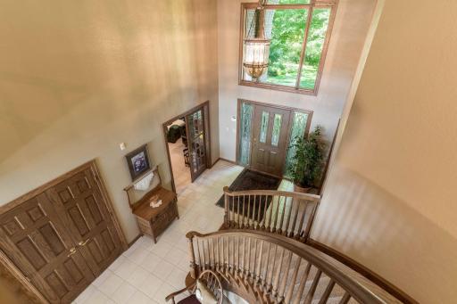 Large foyer with floor to ceiling windows.
Notice the amazing oak curved staircase.
