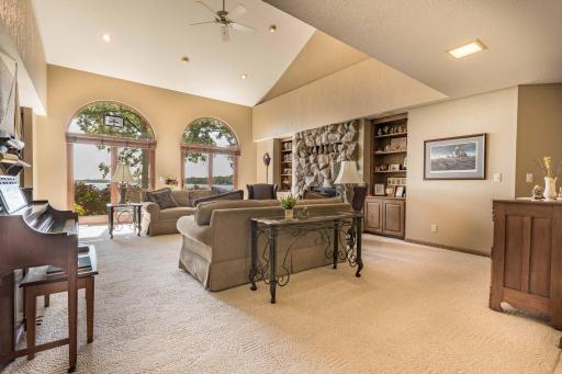 large living room with lake views, patio door to deck and large stone fire place.
(notice the Tall Vaulted ceilings.)
