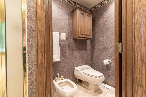 Private primary bath room with toilet and bidet.