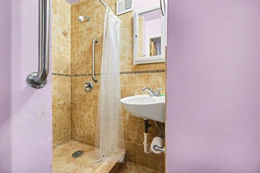Bedroom with attached bath featuring a tiled walk-in shower