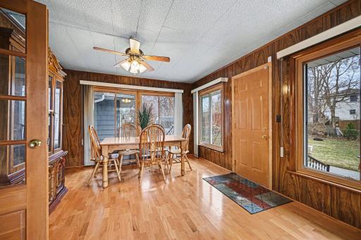 Bright dining area with large windows hardwood floors and backyard access