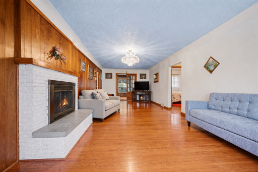 Large living area with hardwood floors and fireplace centrer piece offering a flexible layout.