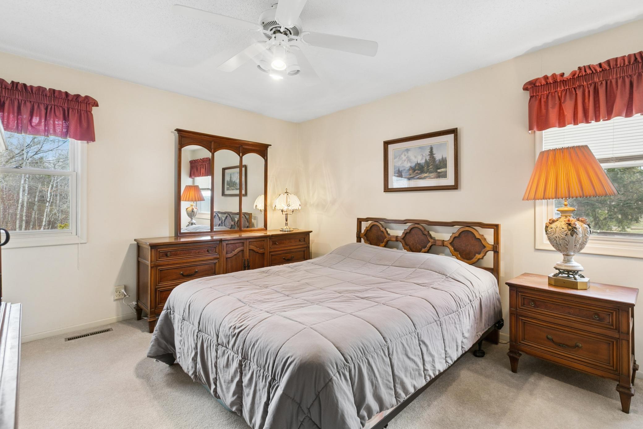 Primary bedroom with corner windows and generous closet space.