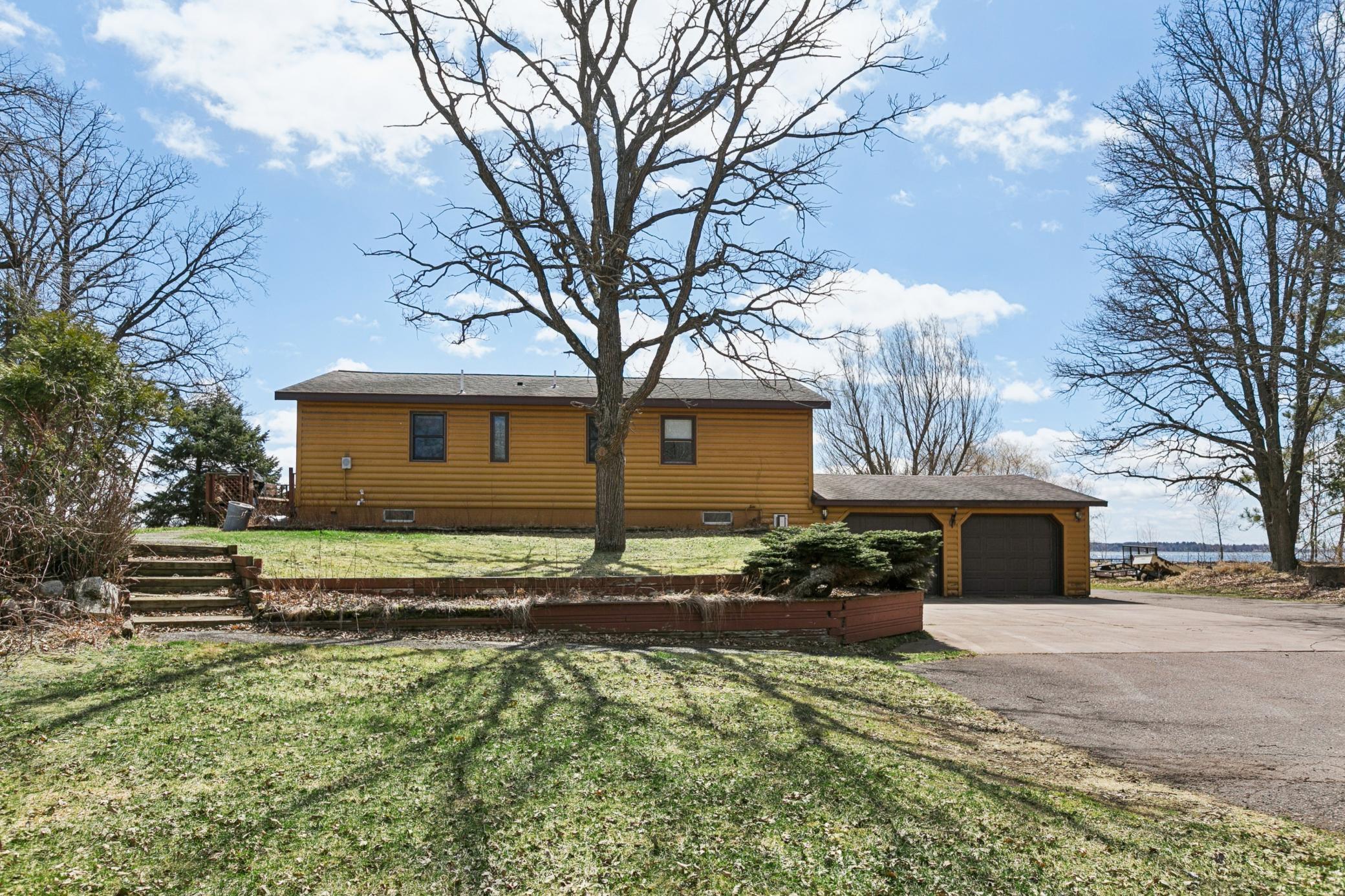 Back of home; walkway to the deck and home entrance to main floor. Concrete and asphalt drive.