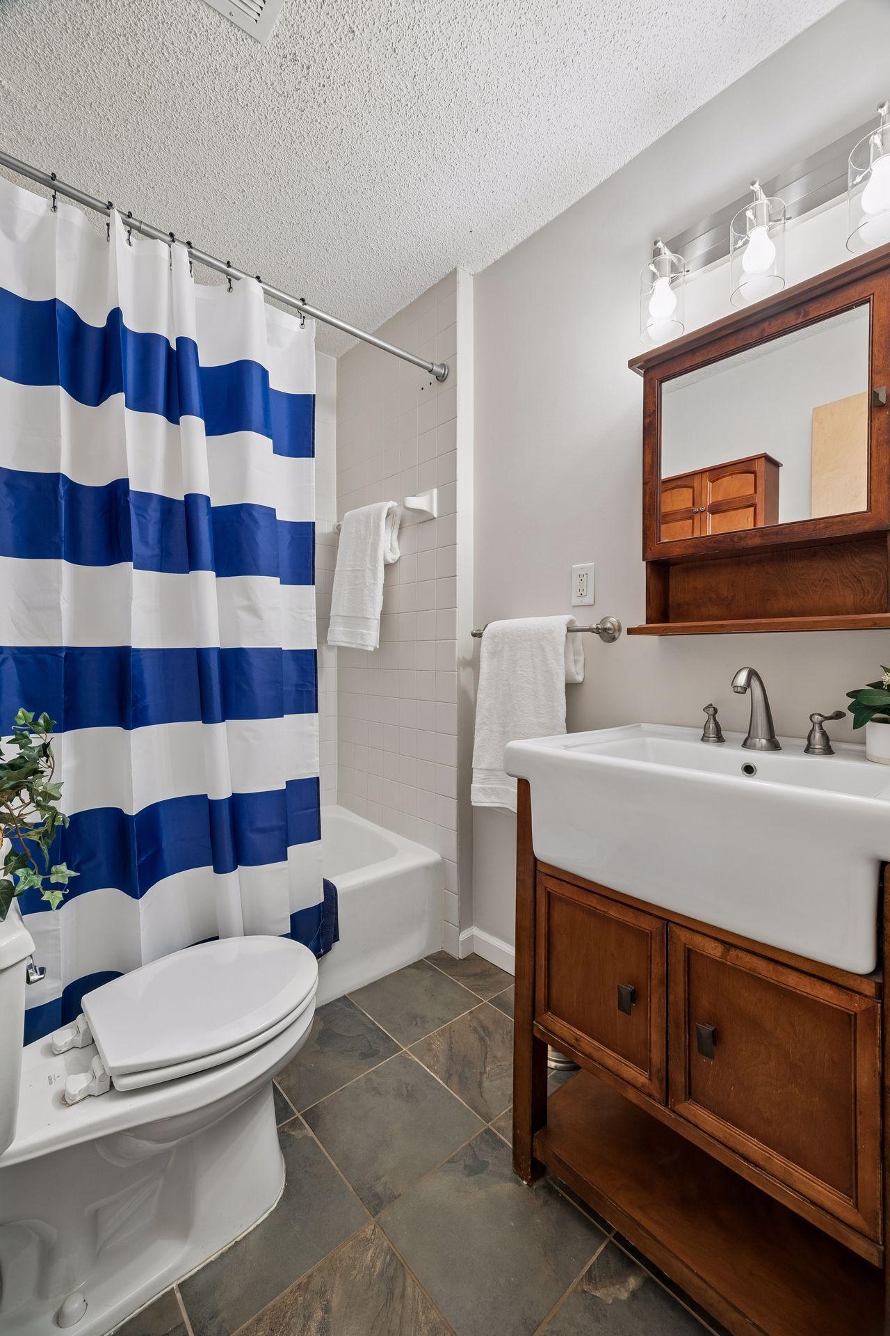 Updated full bath with slate flooring and large sink vanity