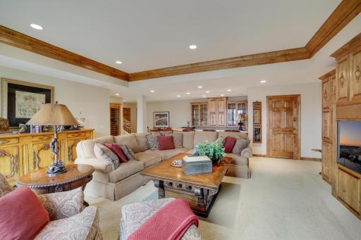 Lower level family room with sunken wet bar to the rear of photo.