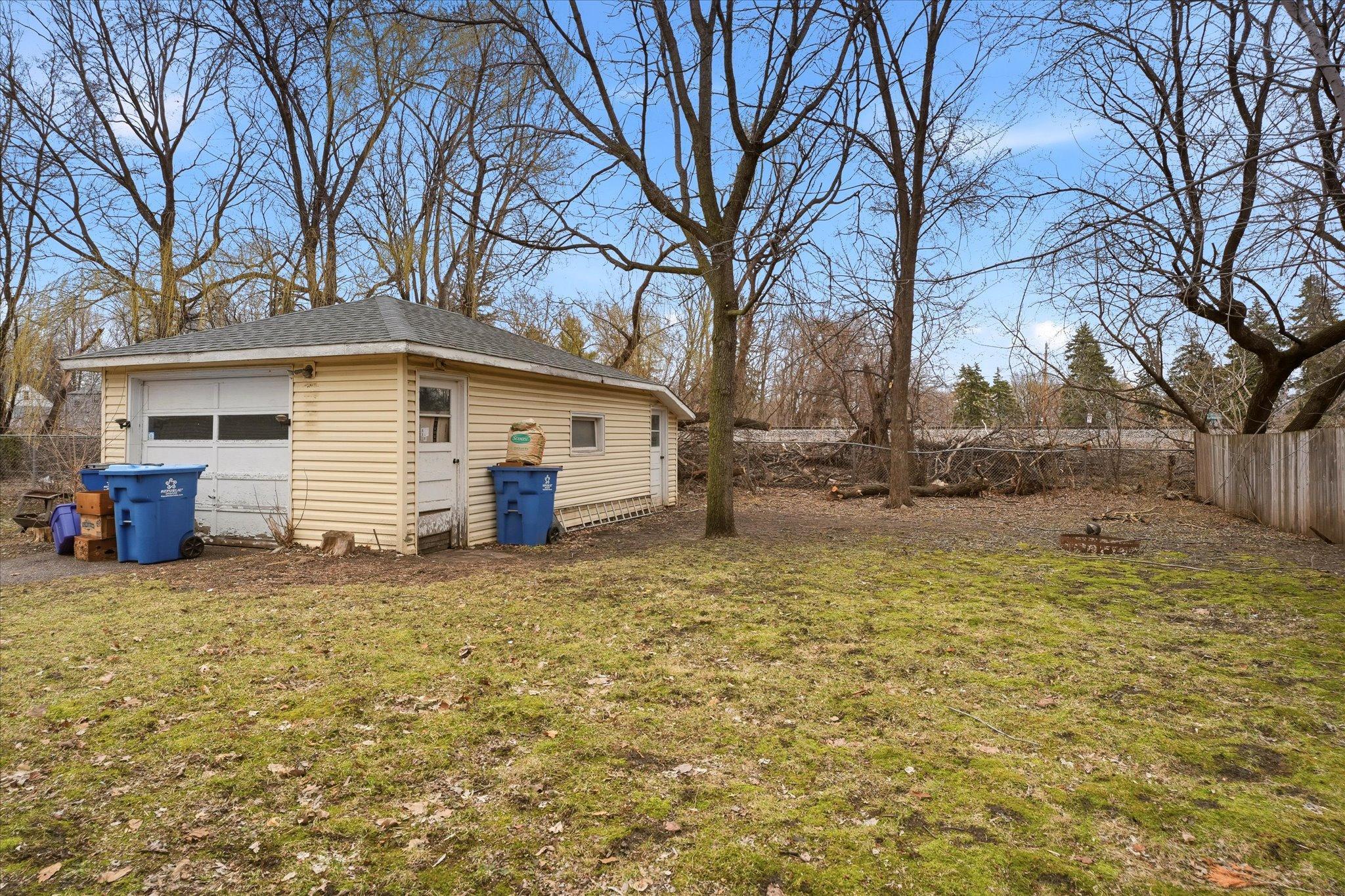 Oversized 1.5 car detached garage with vinyl siding, providing great storage and parking space as well as a service door to a shed area.