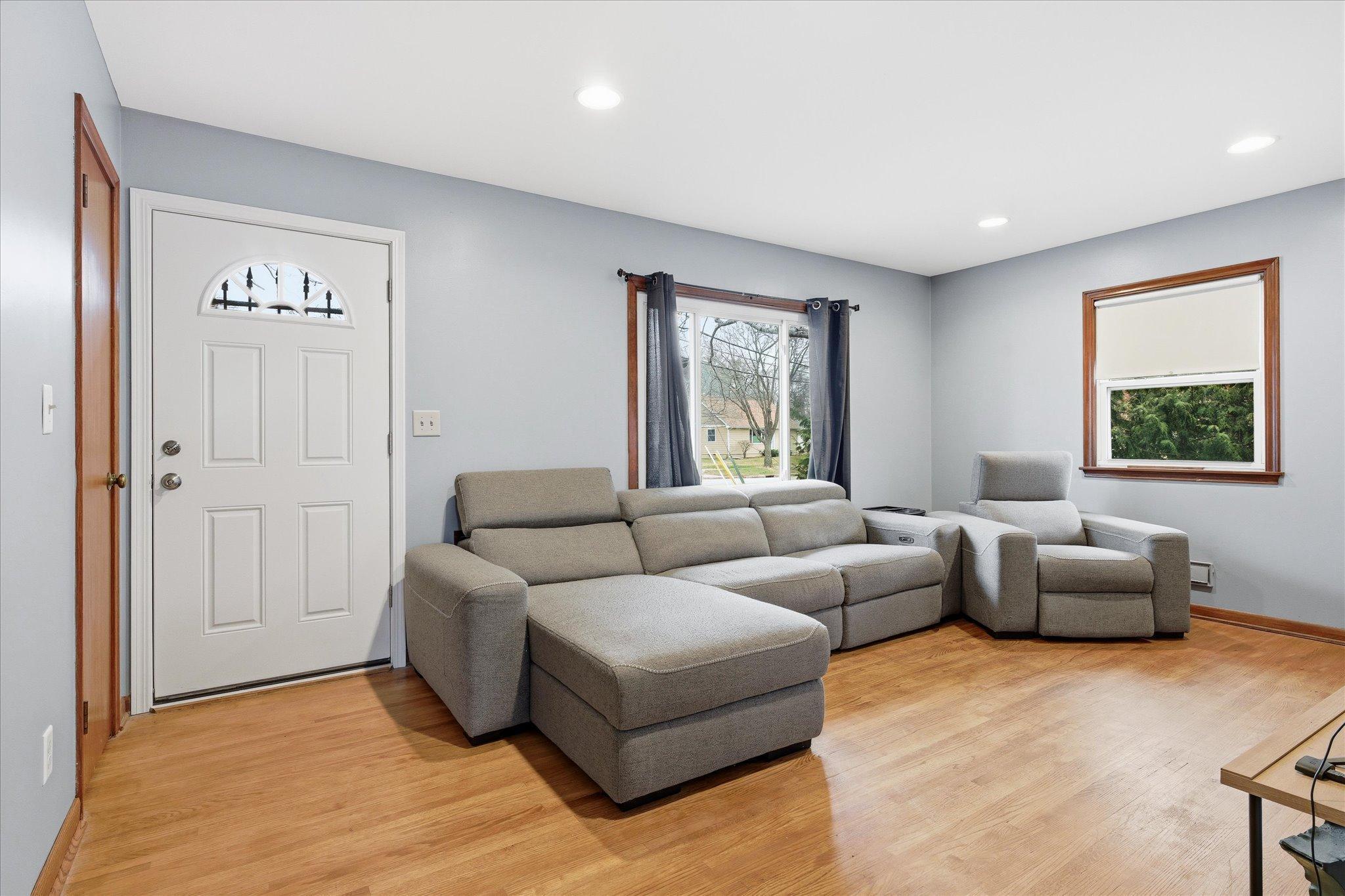 Bright and inviting living room with large front window, recessed lighting, hardwood floors and has been freshly painted.
