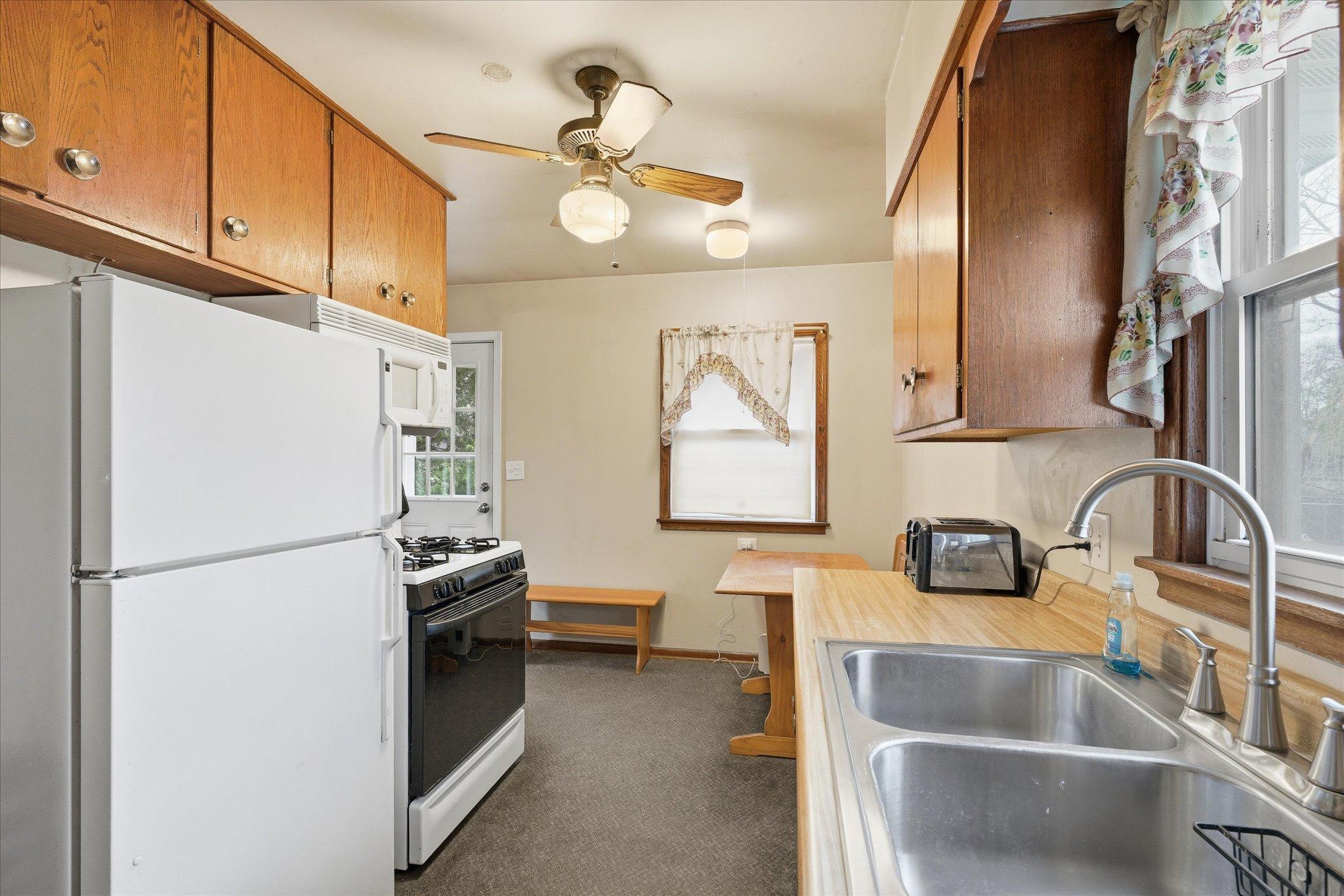 Kitchen featuring gas range, upper cabinetry, and efficient workspace.