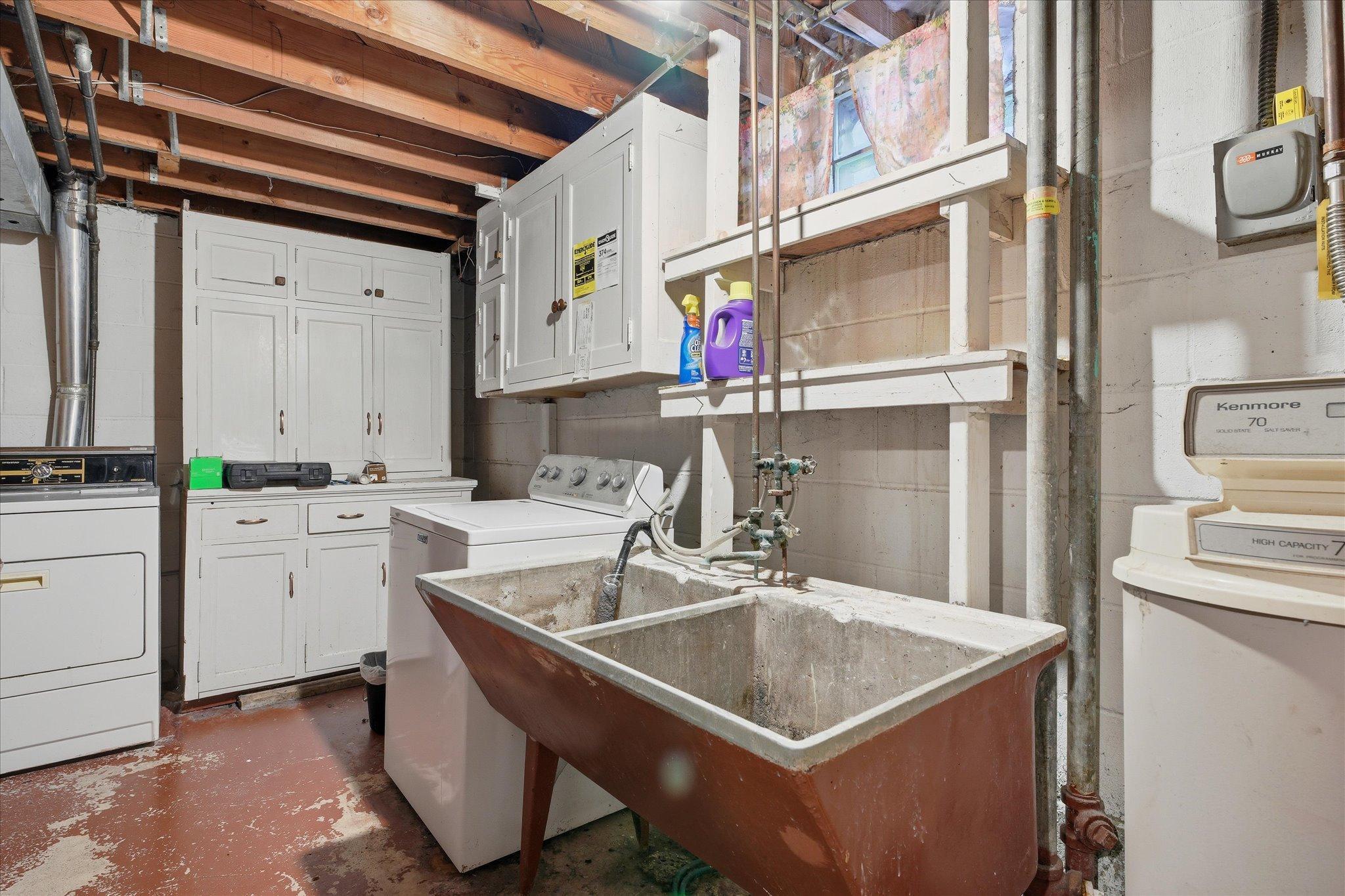 Functional laundry area with utility sink and ample storage, making everyday tasks convenient.