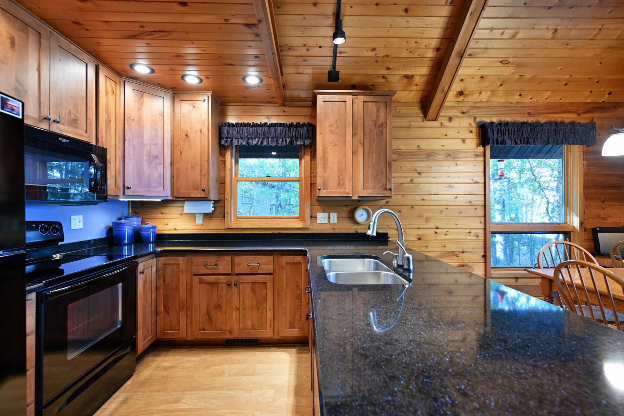 The kitchen is a well lit workspace with recessed, track and undercabinet lighting.
