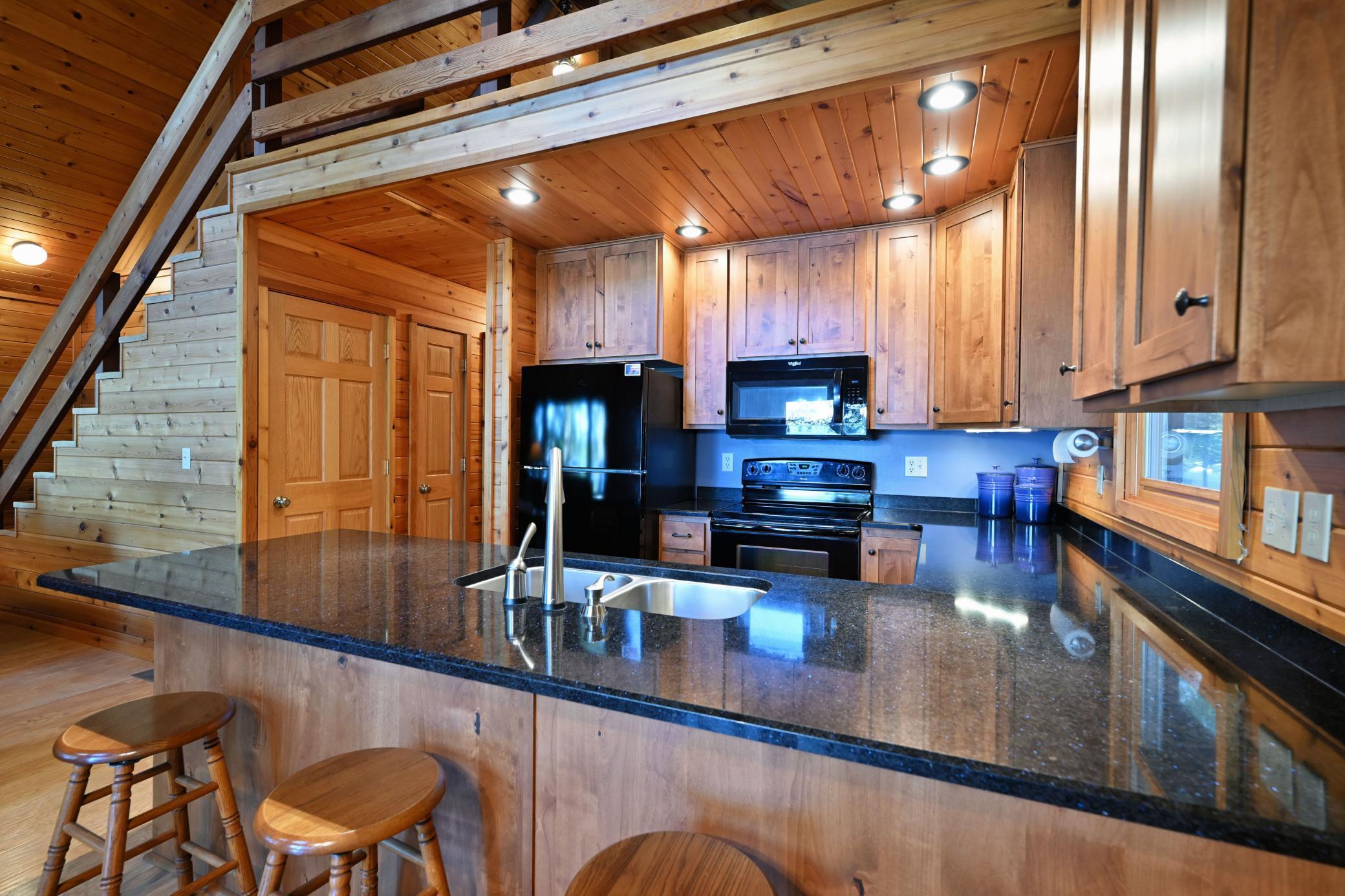 A full suite of black appliances coordinate with the black granite countertops.