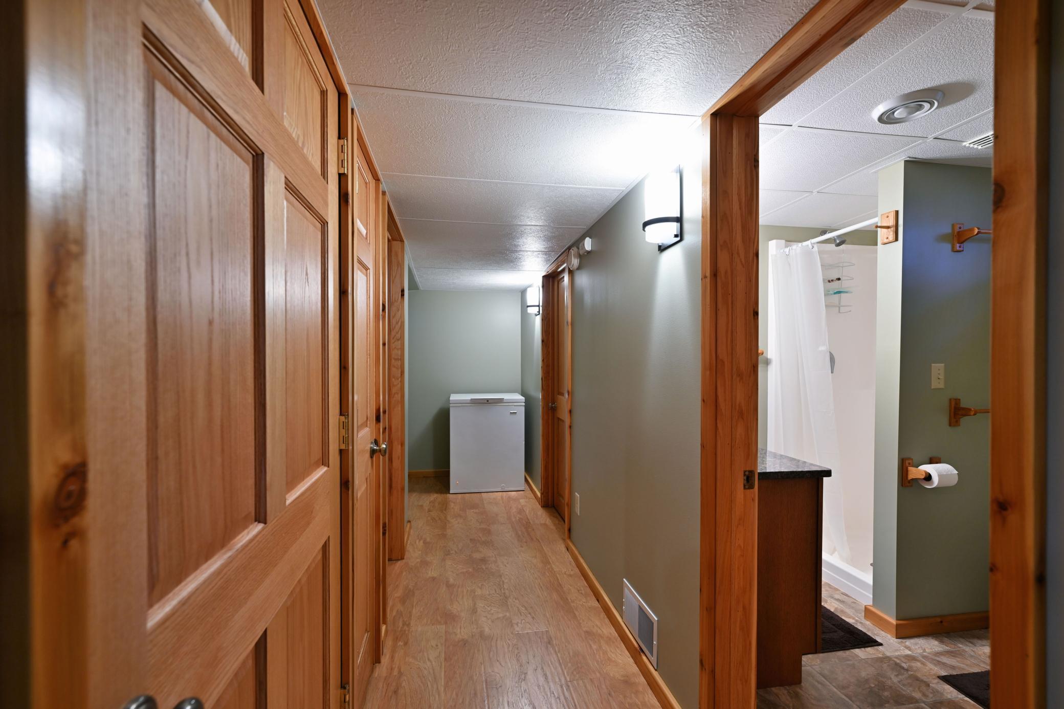 A hallway leads to the lower level bathroom. There are paneled doors throughout the home.