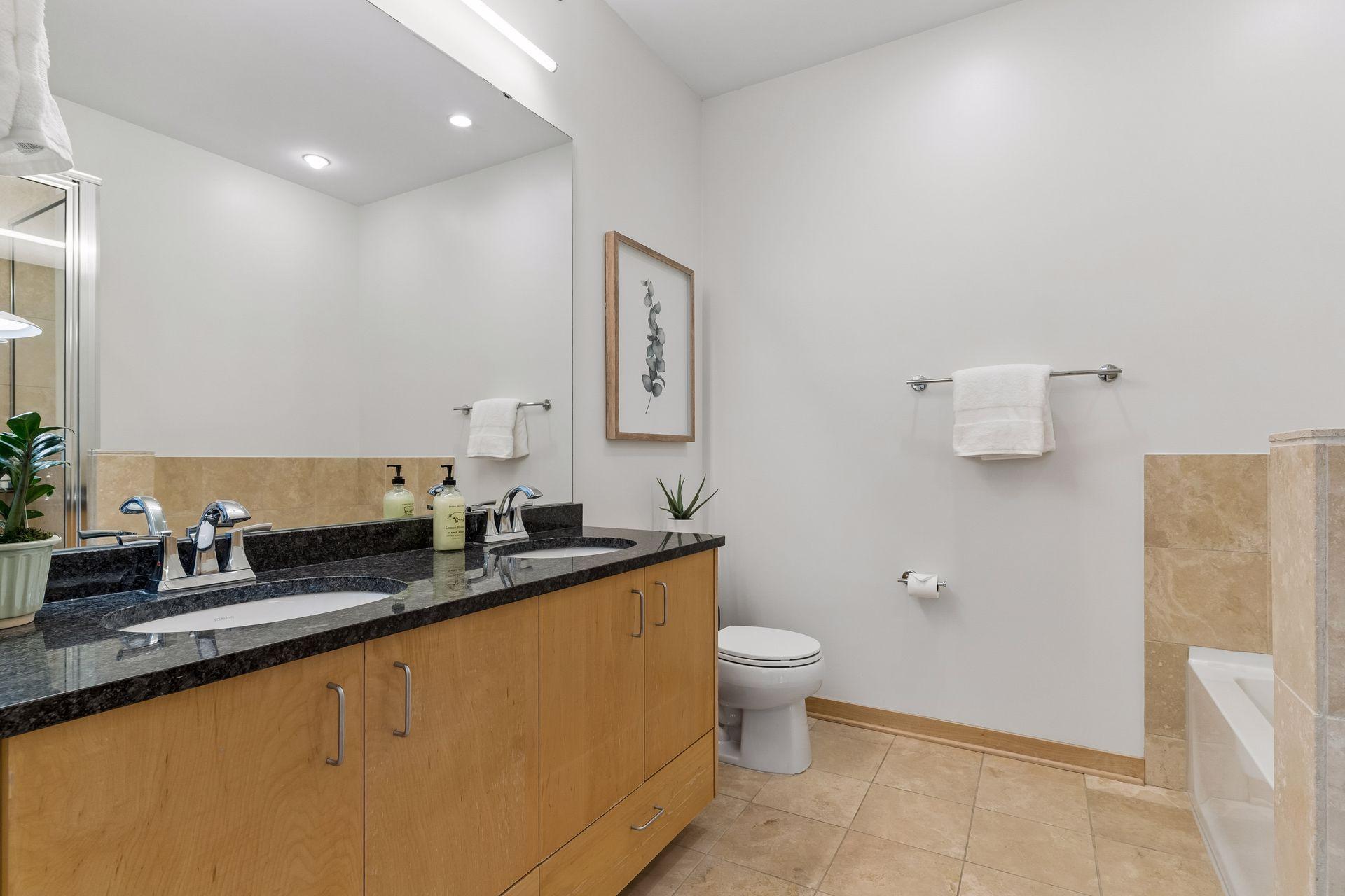 Private ensuite bath with granite double sink vanity.