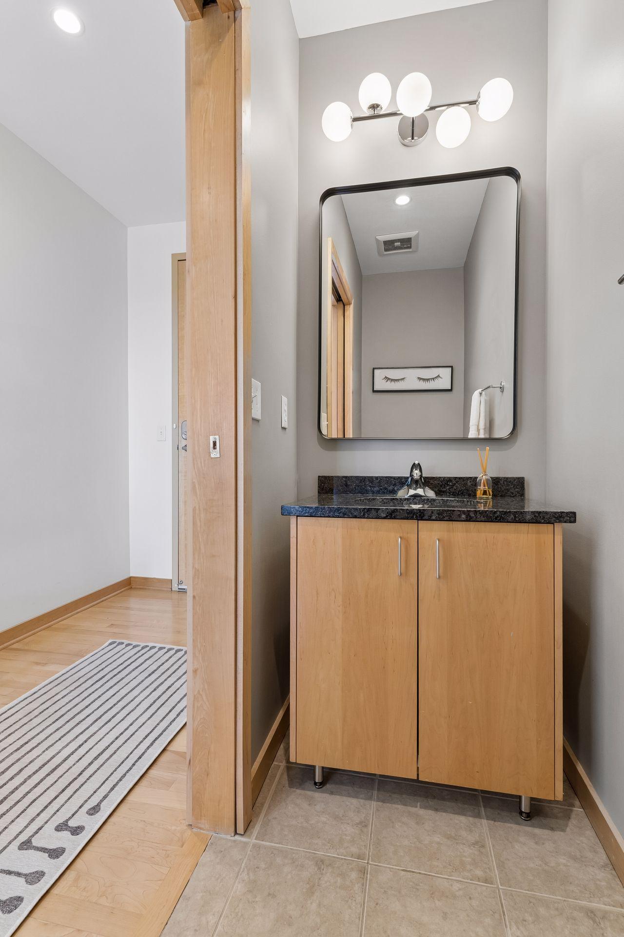 Powder room with granite vanity and updated lighting.
