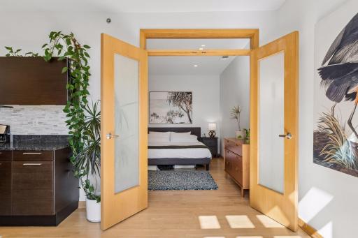 Large primary bedroom with french doors and transom window.