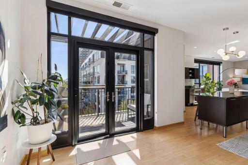Double steel French doors, with transom window and sidelights, provide natural light year-round.