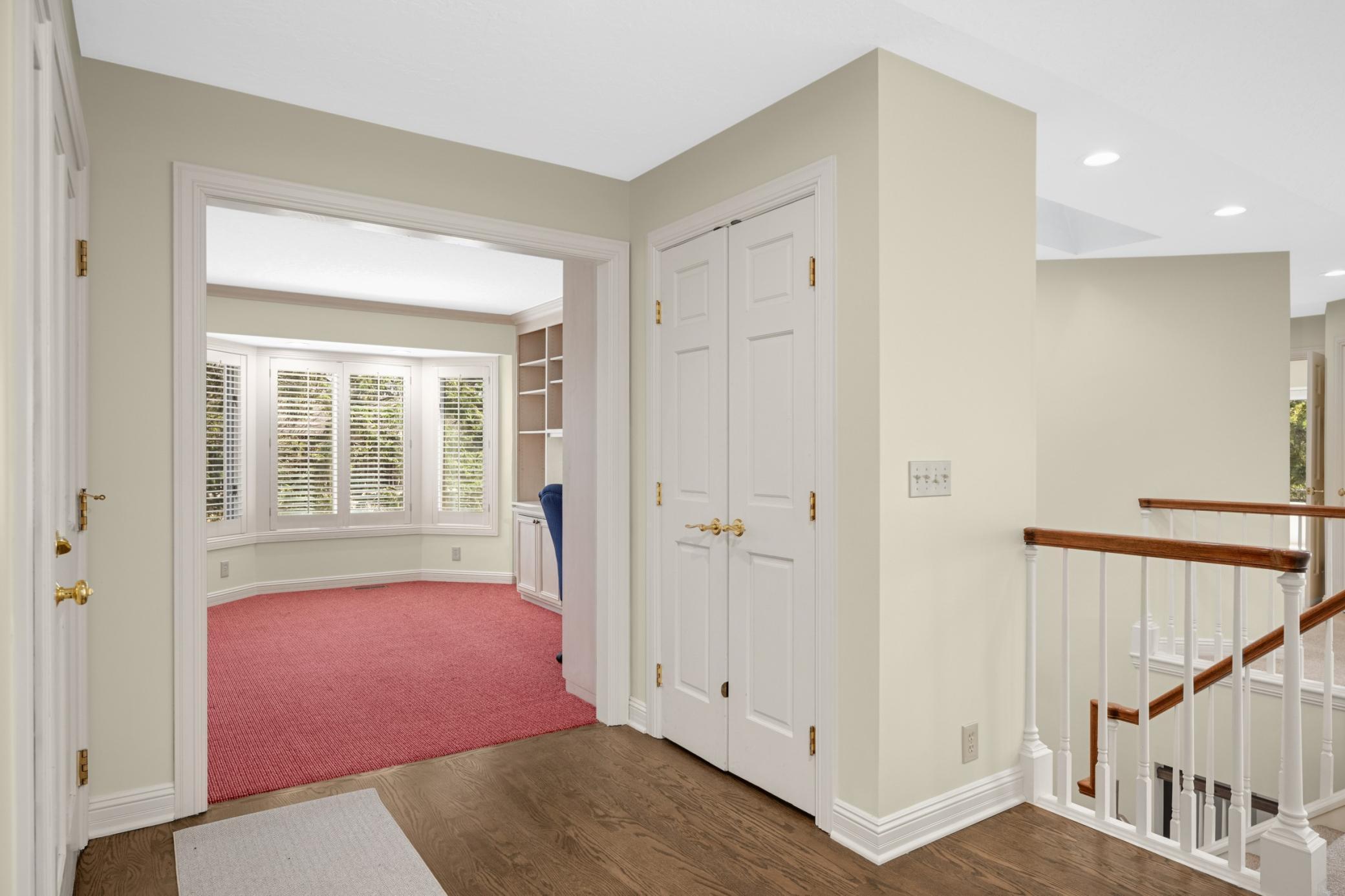 A pretty foyer with hardwood floors and an open staircase to the walkout level