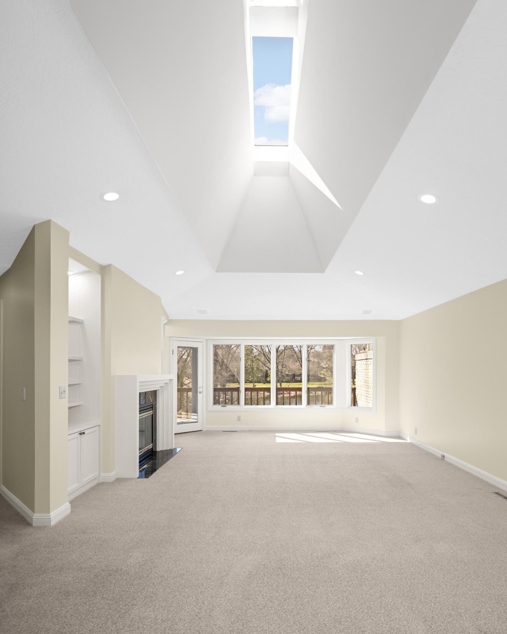 Vaulted living room overlooks the pond and a large skylight for natural light all day.