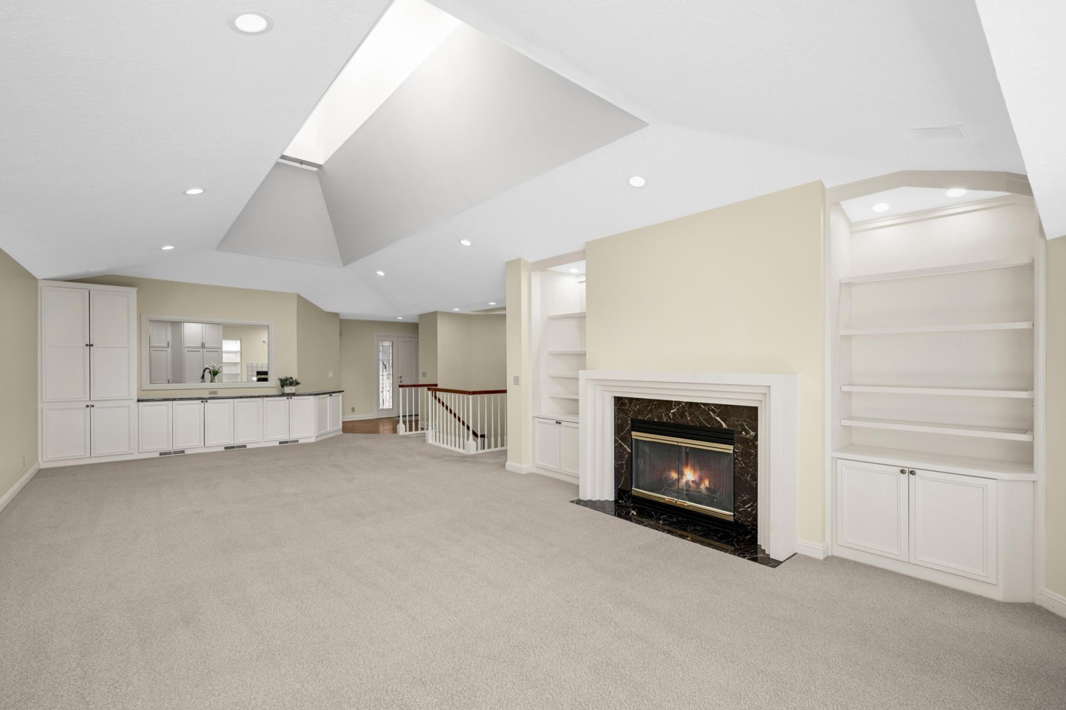 A pretty gas fireplace flanked by lite display cases