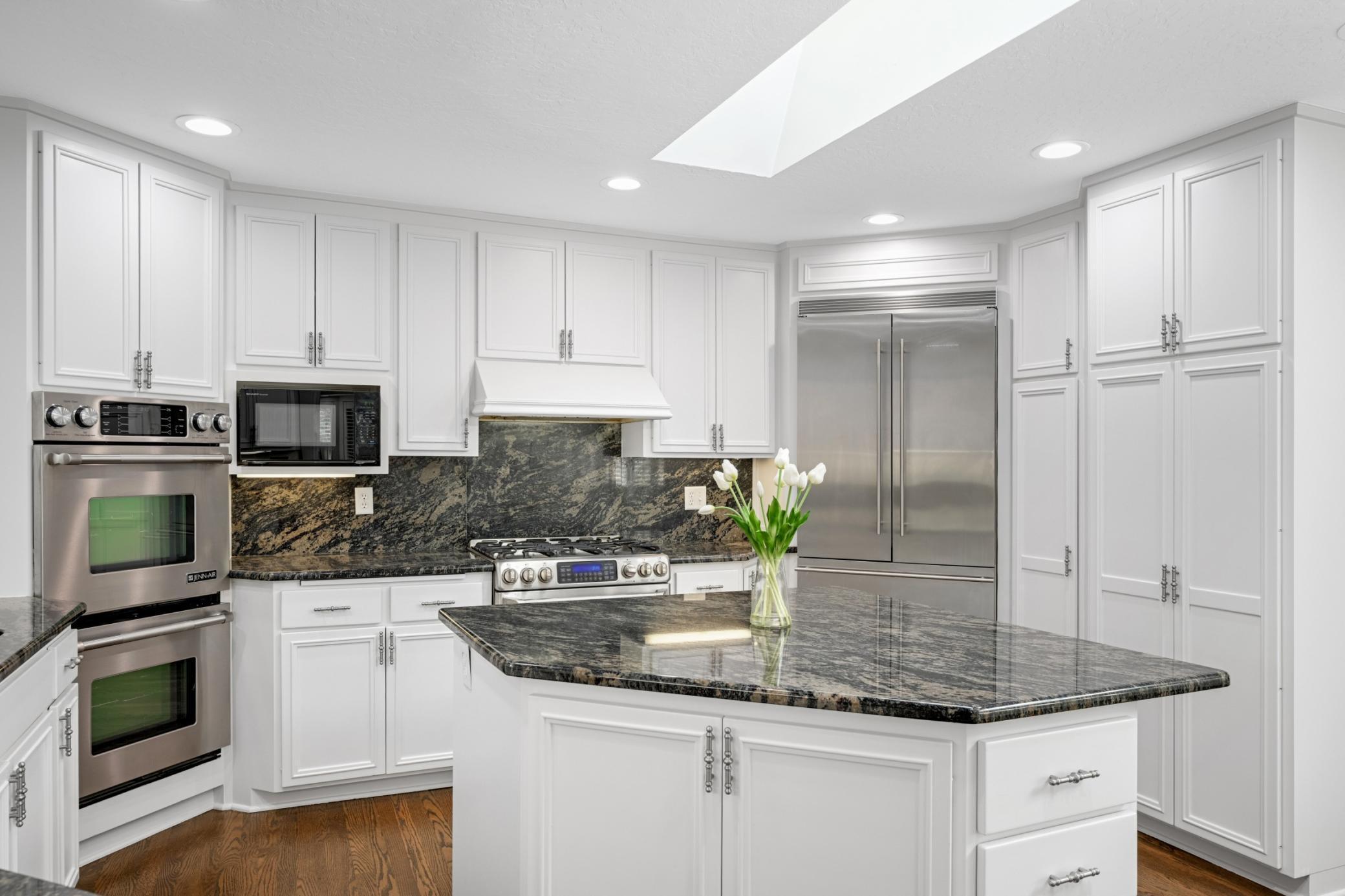 The center island has a breakfast bar and a skylight above for natural light.