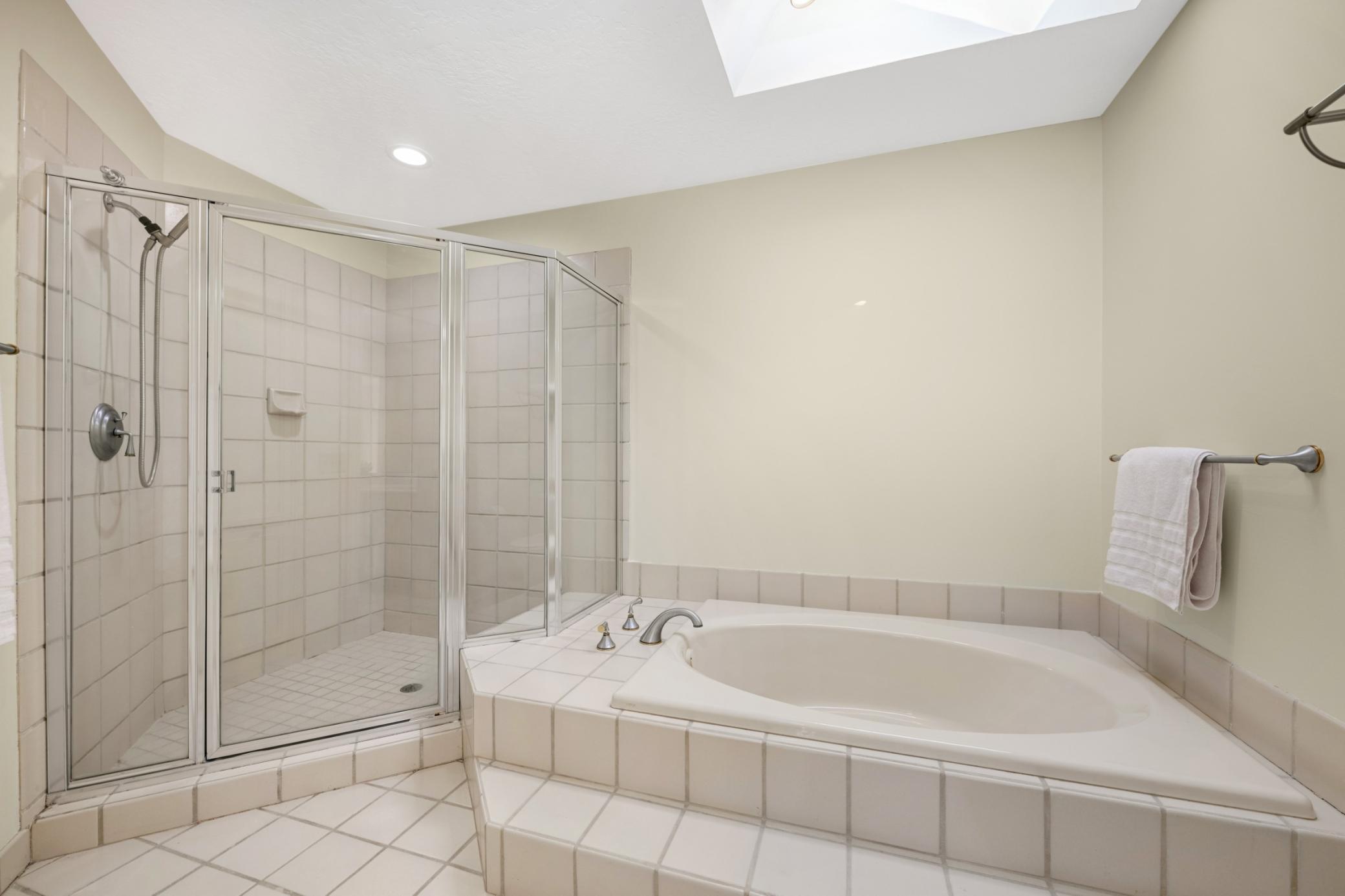 The primary bath has a large soaking tub, a large shower and skylight for natural light.