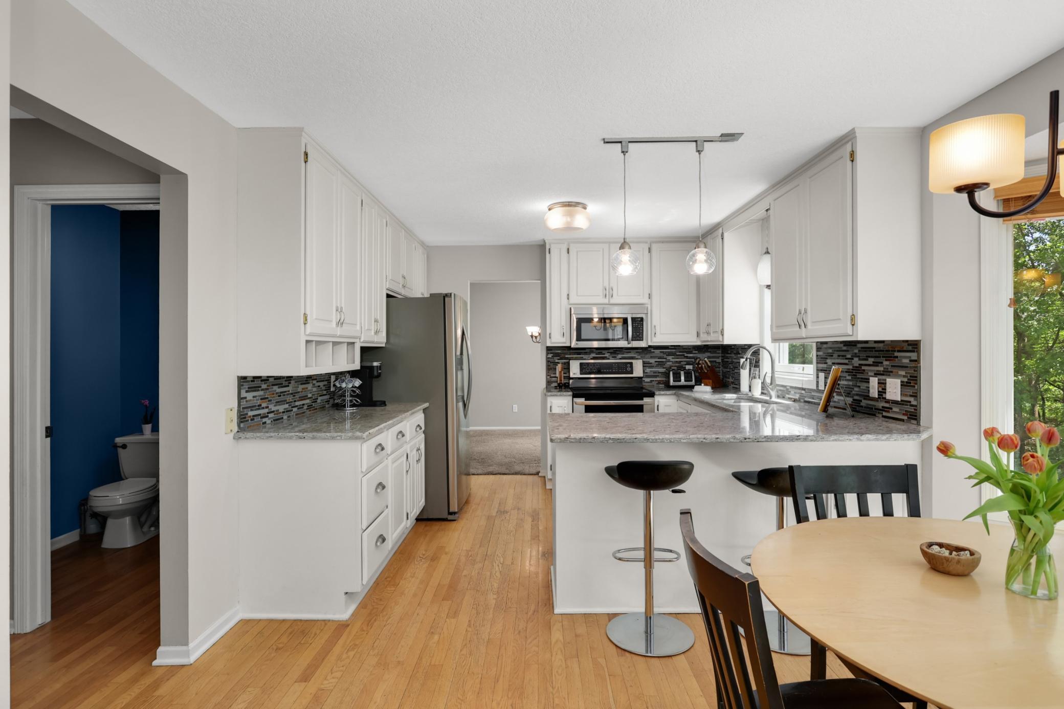 Kitchen with breakfast bar flows into casual dining area