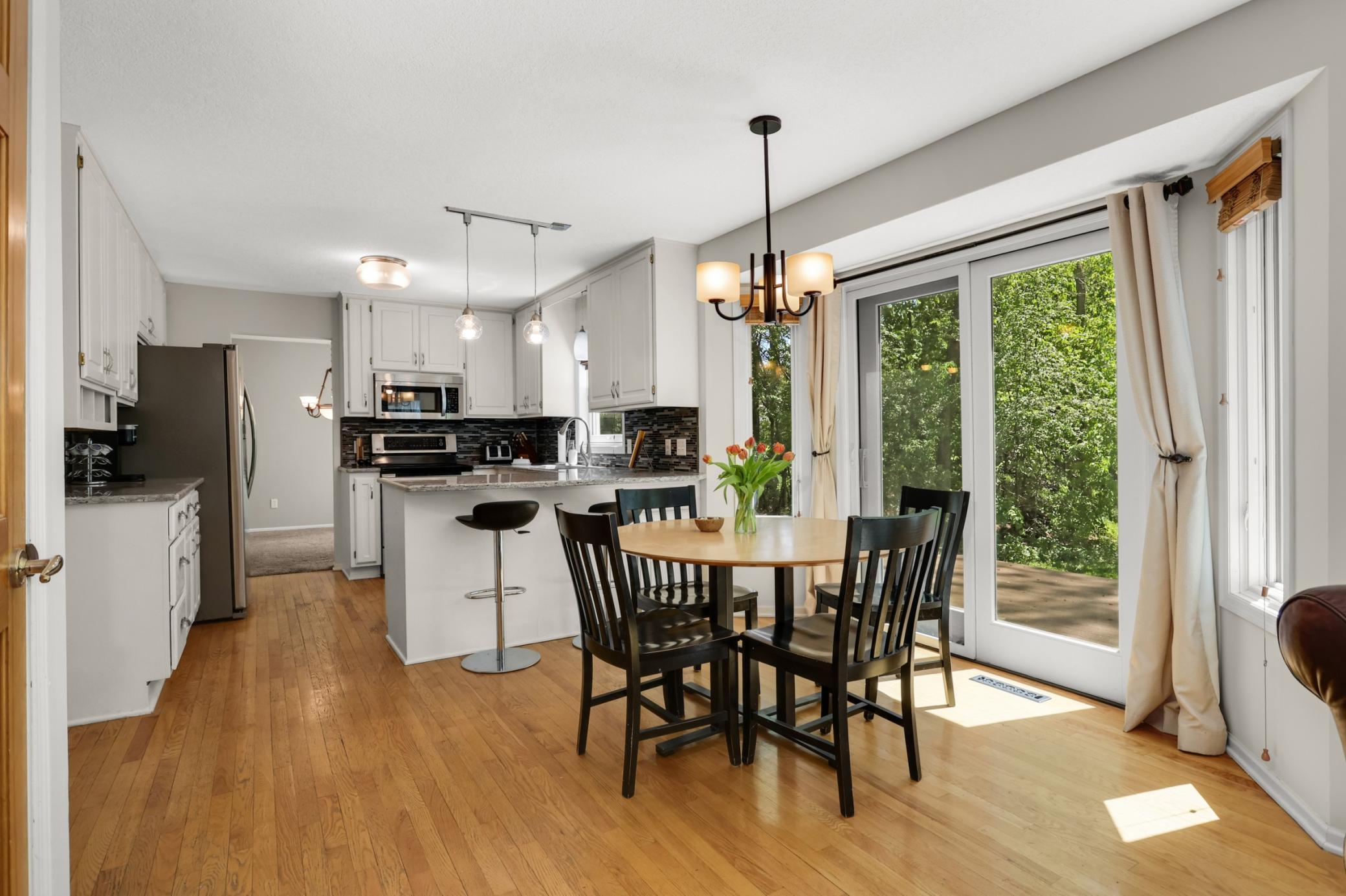 Main floor living spaces flow to beautful deck & patio overlooking the private and wooded yard