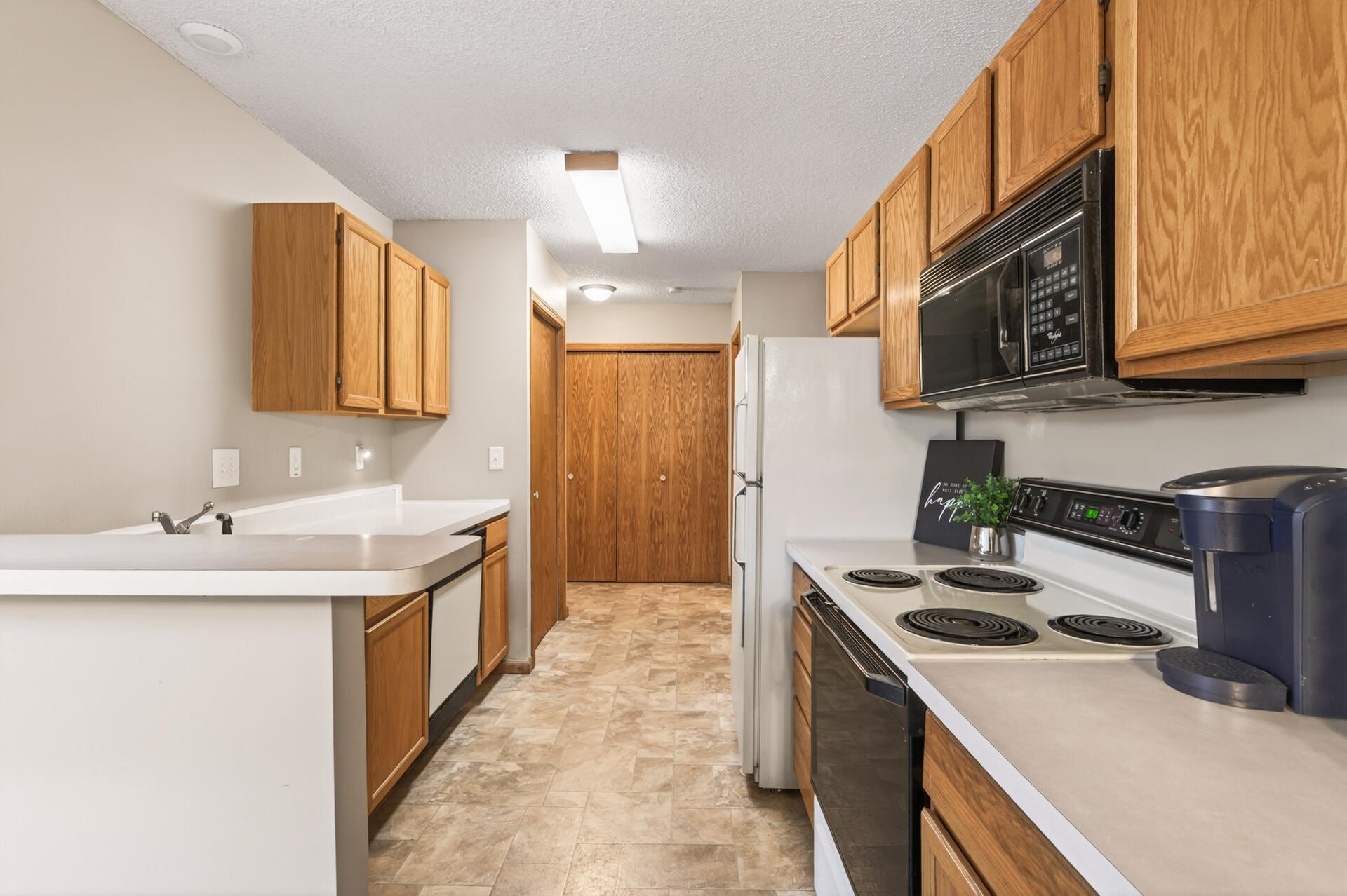 Straight ahead is the main floor laundry, half bath and steps to lower level, garage entrance