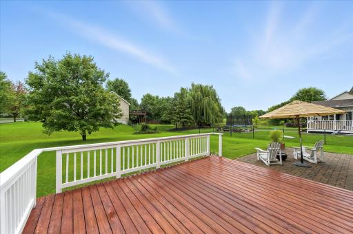 The dining room opens to a deck and paver patio overlooking the large, flat backyard.