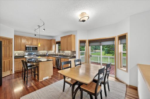 The dining room opens to a deck and paver patio overlooking the large, flat backyard.