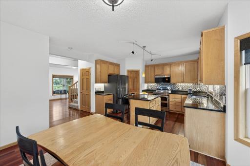 The kitchen includes abundant cabinet space, a walk-in pantry, stainless steel appliances, stylish countertops, backsplash, and an island for meal prep or casual dining.