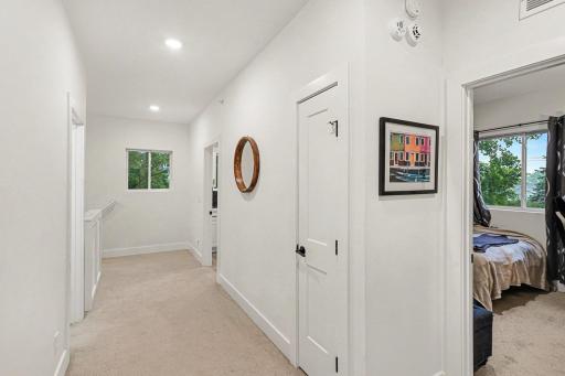 Upper level hallway has access to the large laundry room, three bedrooms and a full hall bath.