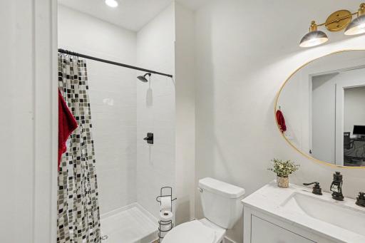 Main level 3/4 bath has a modern sink with drawers and space for baskets on the shelf.