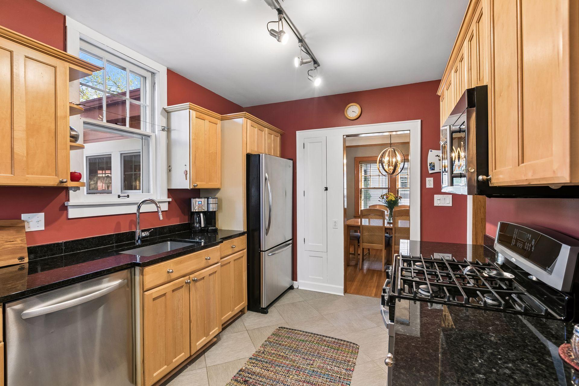 The kitchen features stainless steel appliances, granite countertops, and a plethora of storage space.