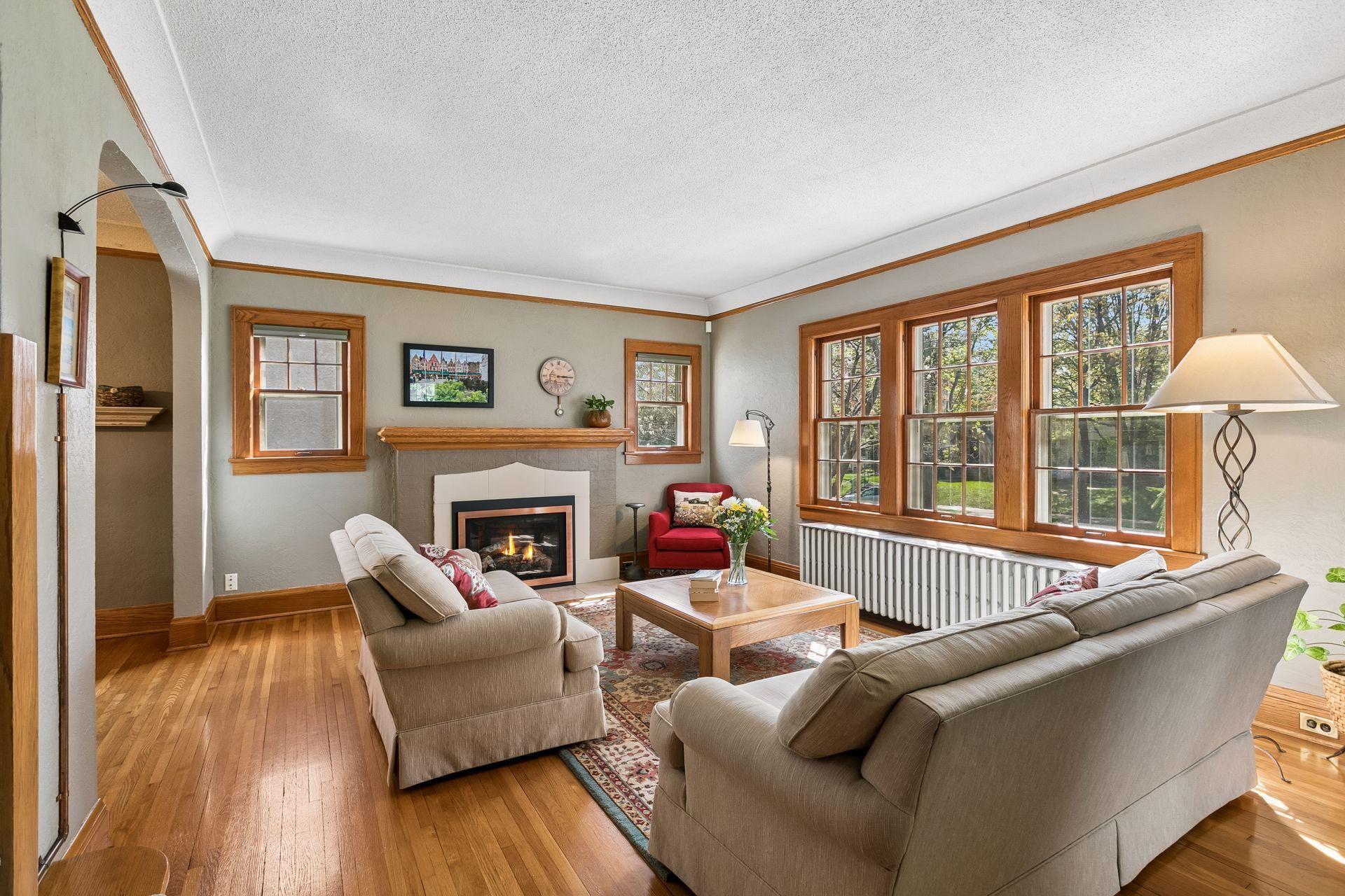 Bright, spacious living room with plenty of room to gather, featuring a cozy gas fireplace installed in 2019 and beautiful hardwood flooring throughout.