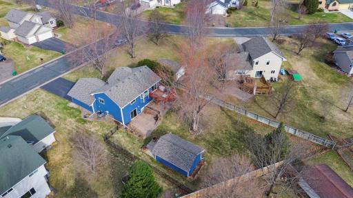 This aerial view of the back of the home and property shows the great fenced backyard, large mature trees, awesome shed, great patio and deck! There is so much to love here!