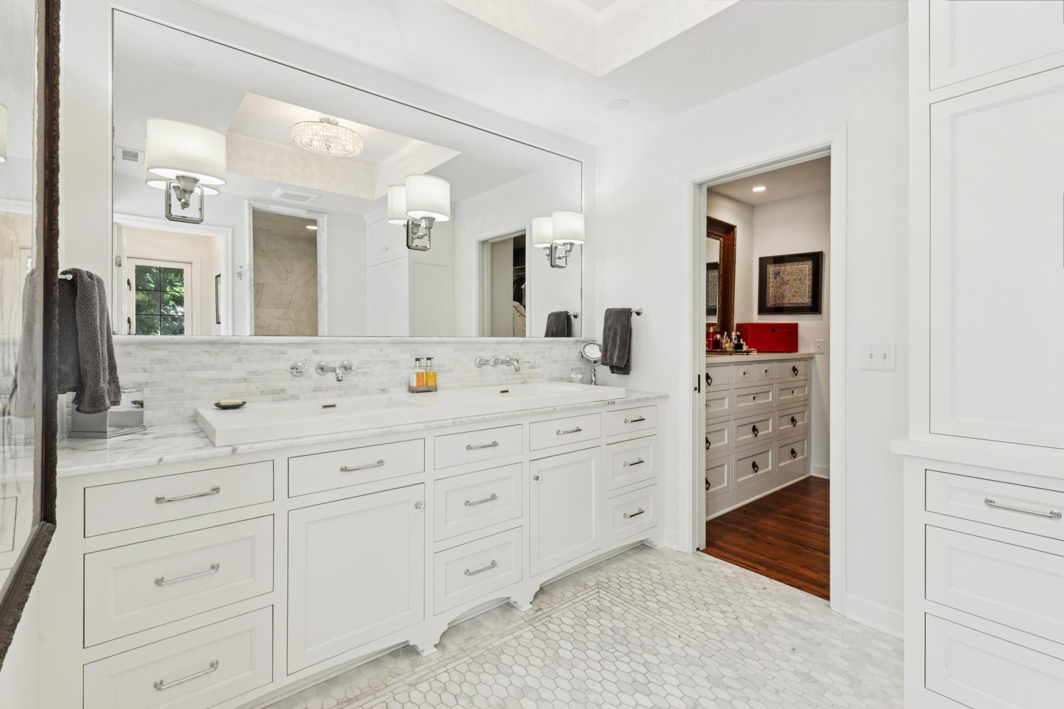 Gorgeous marble bathroom with in-floor heat and mirror fogger integrated with mirror lighting and double sinks