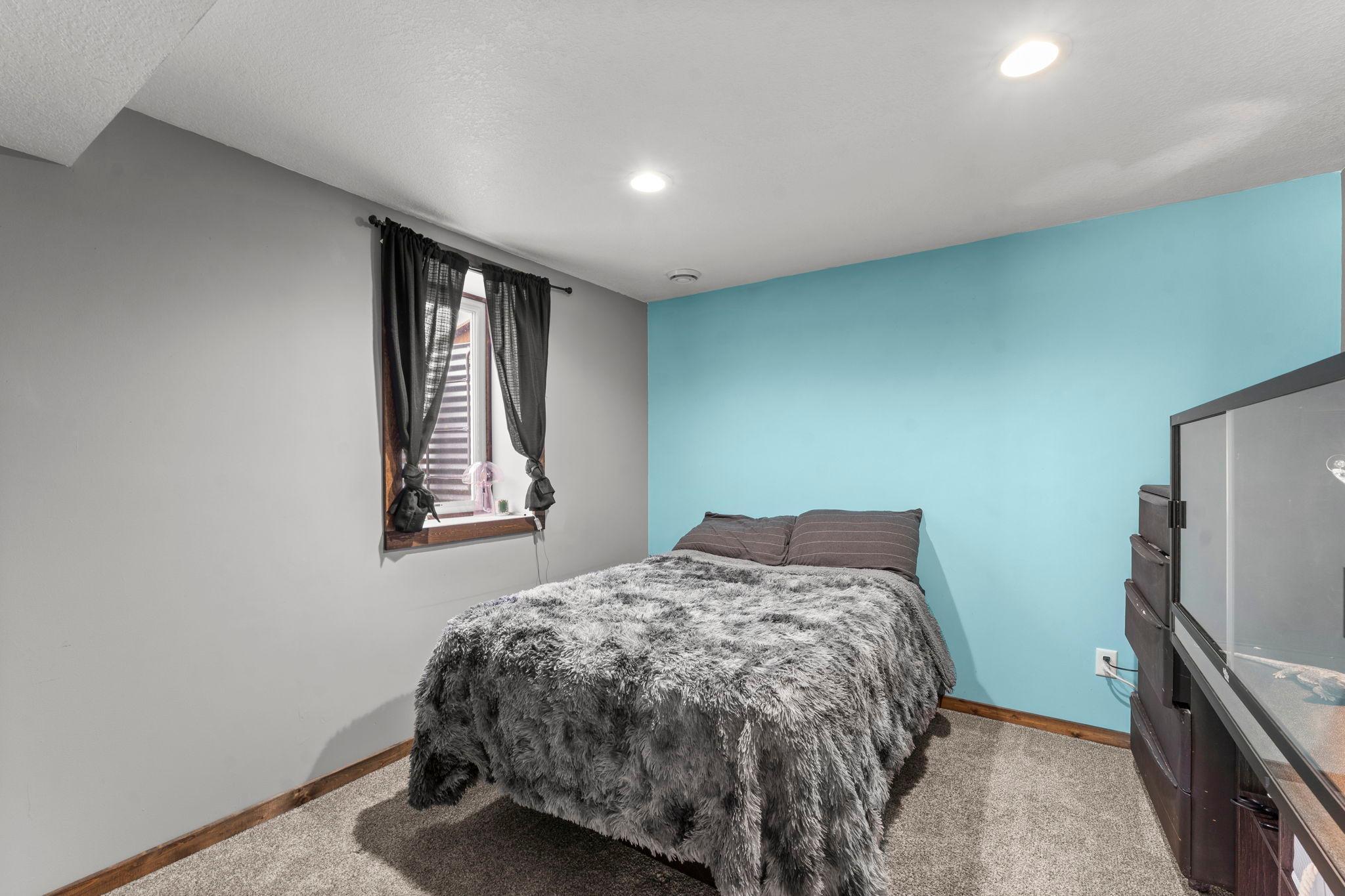 The lower-level fourth bedroom features carpet, recessed lighting, and an egress window.