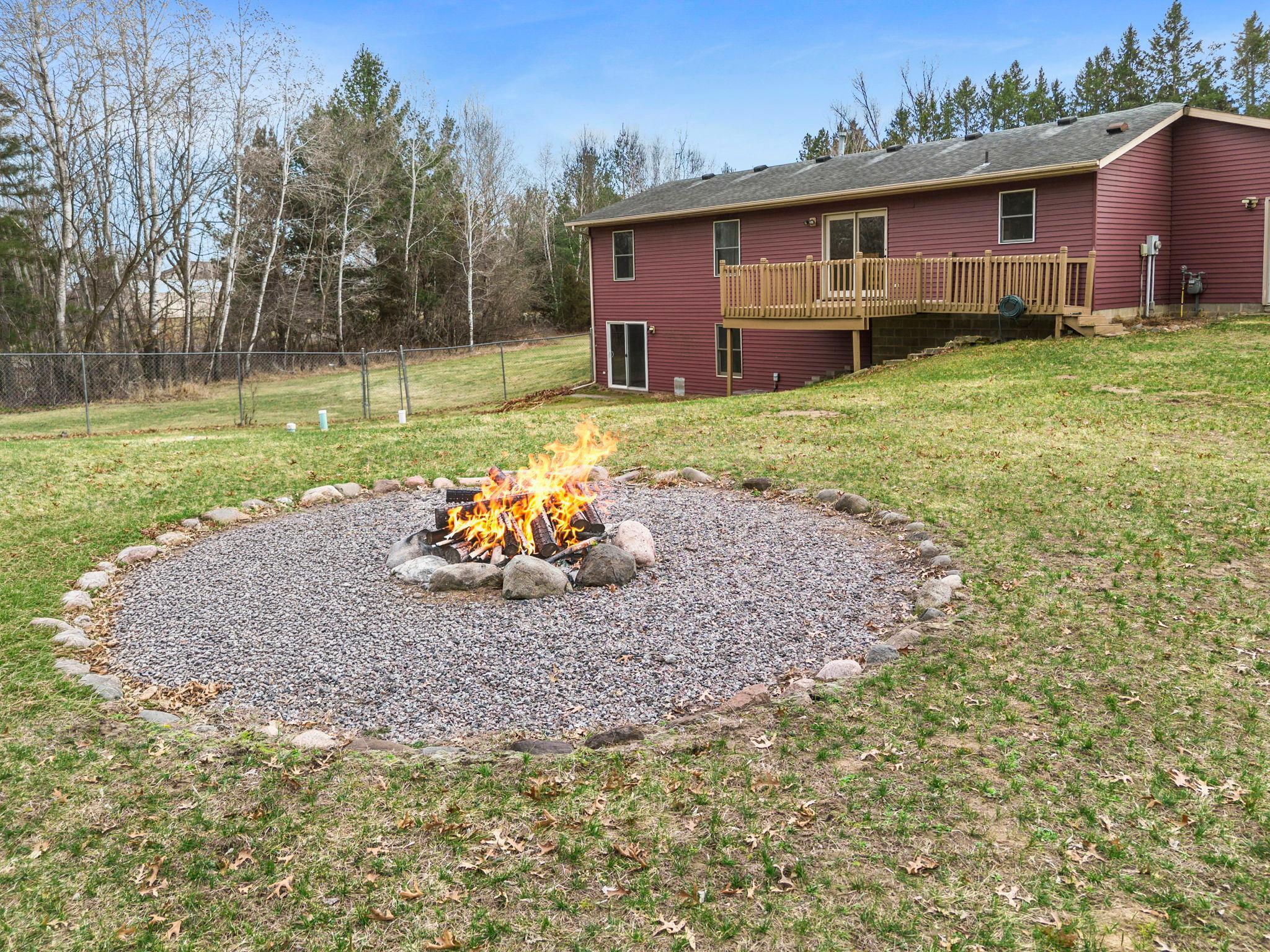 The backyard is a standout feature, offering a spacious, fully fenced yard with a fire ring—perfect for entertaining and enjoying summer nights.