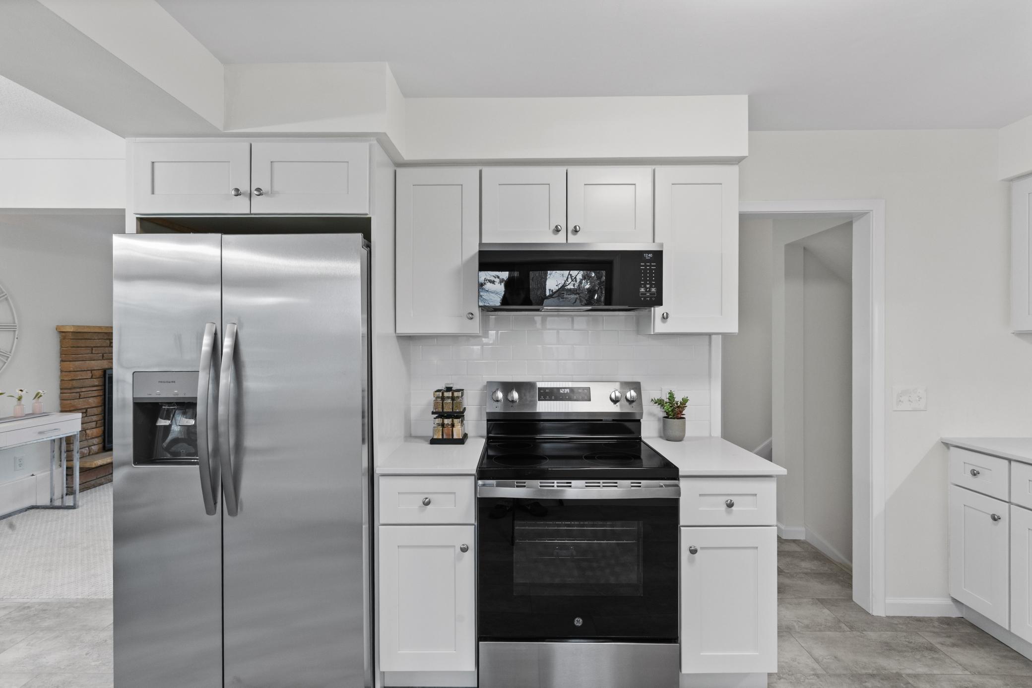 Brand new kitchen with white cabinets and stainless steel appliances.