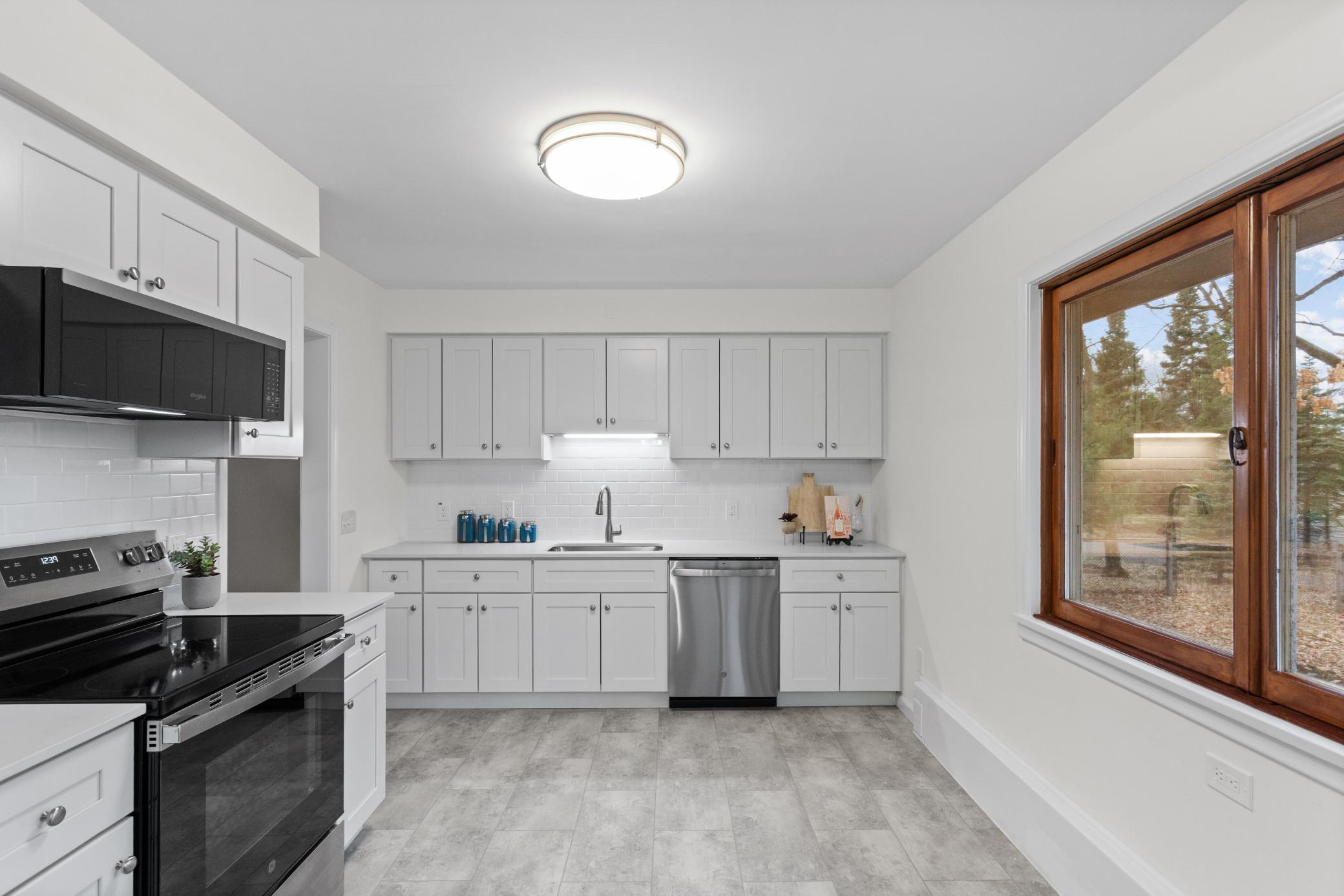 Brand new kitchen with white cabinets and stainless steel appliances.