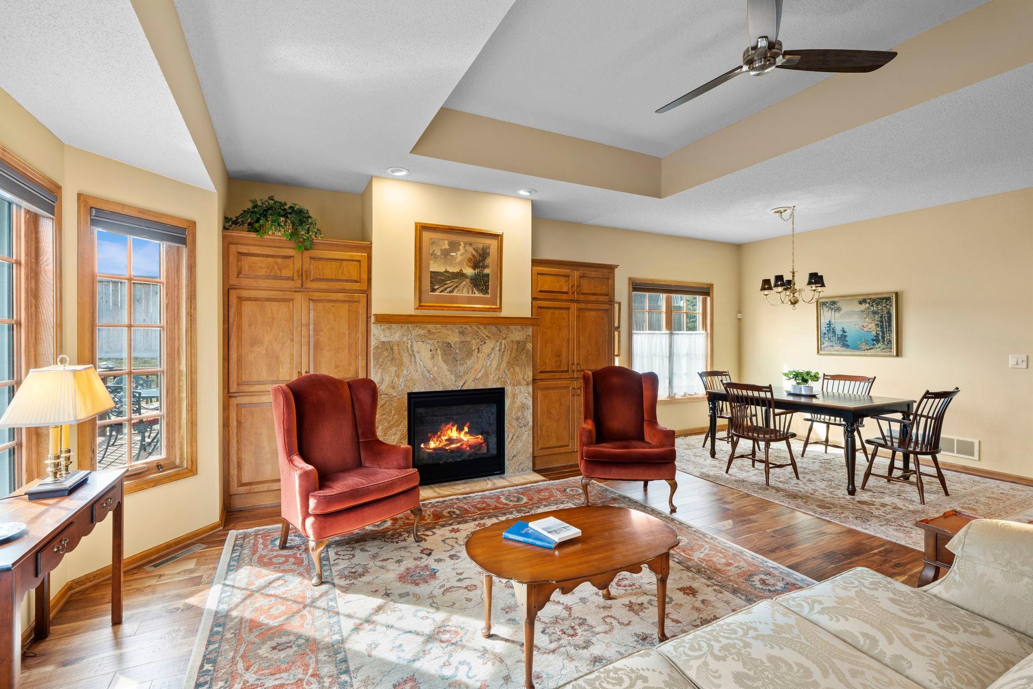 Beautifully redone gas fireplace with a travertine tile surround.