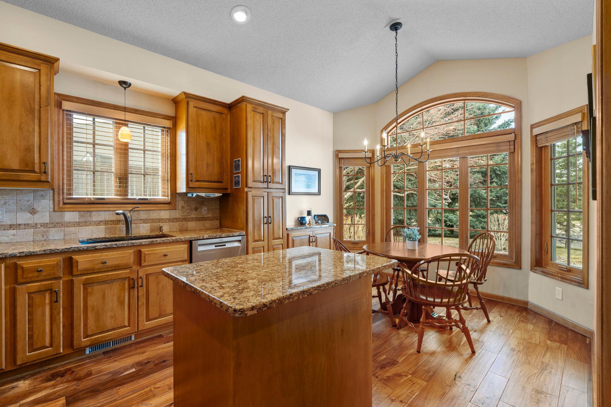 The kitchen features 11-foot vaulted ceilings and new stainless steel appliances, featuring an updated gourmet stove with a gas cooktop and electric double oven.