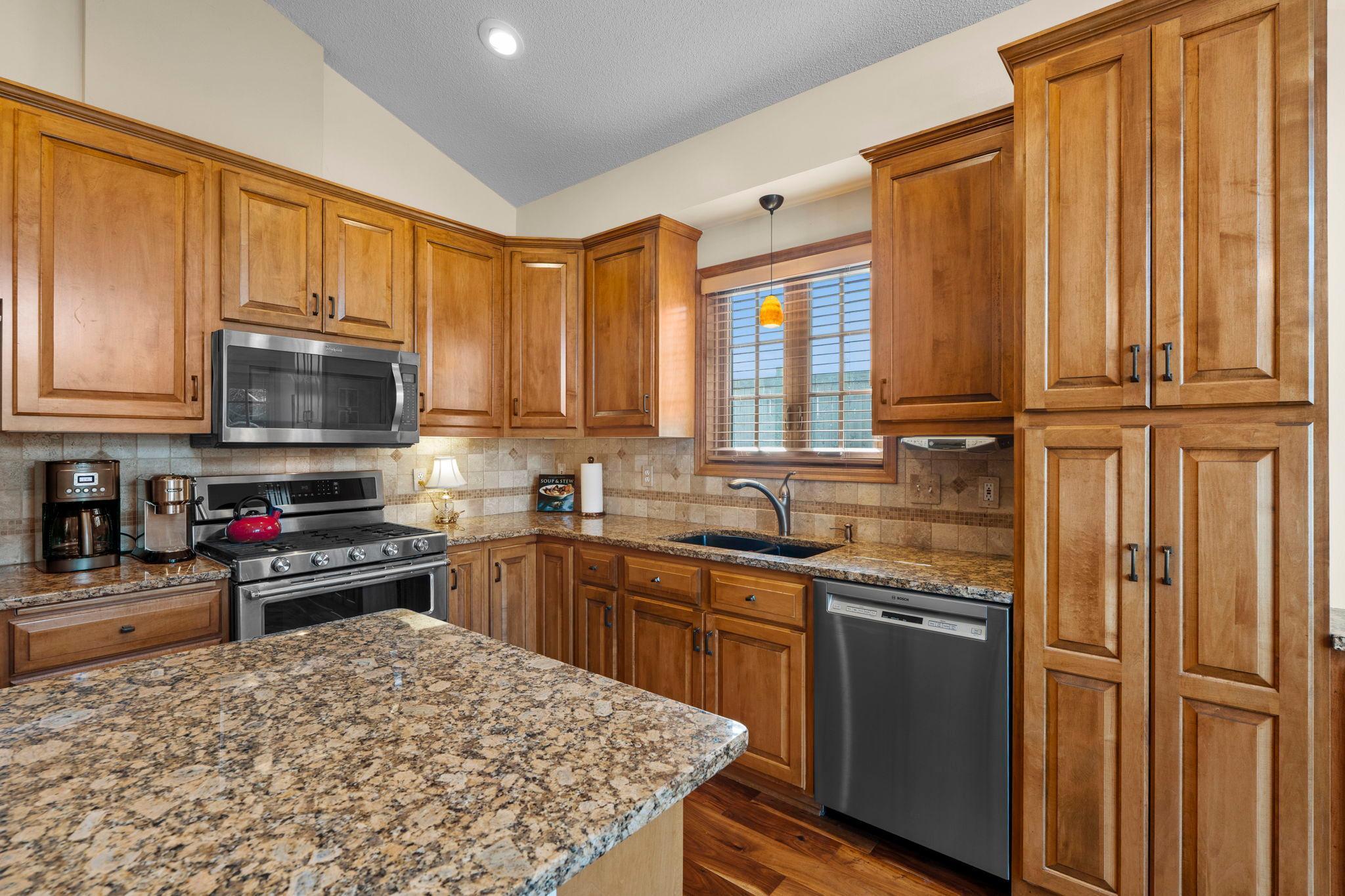 A new refrigerator (2026), granite countertops, and oak cabinetry provide both style and excellent storage.